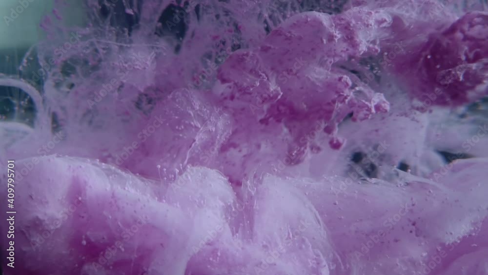 Violette Acrylfarbe erzeugt Abstrakte Gebilde im Wasser