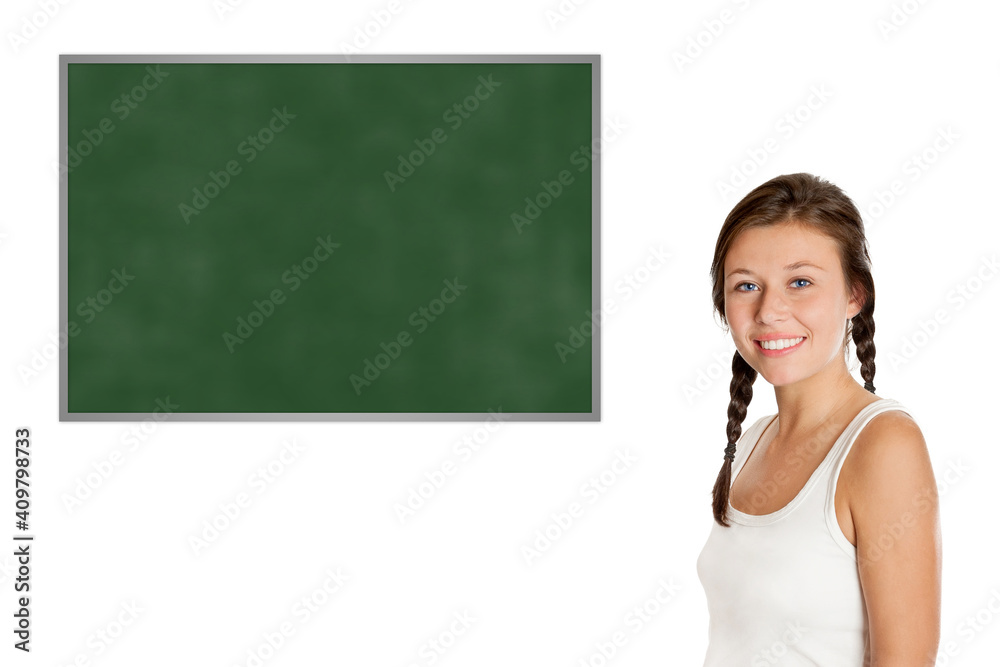 Elder schoolgirl in front of a blank chalkboard, model is eighteen years old, isolated on white background Elder schoolgirl in front of a blank chalkboard, model is eighteen years old, isolated on white background