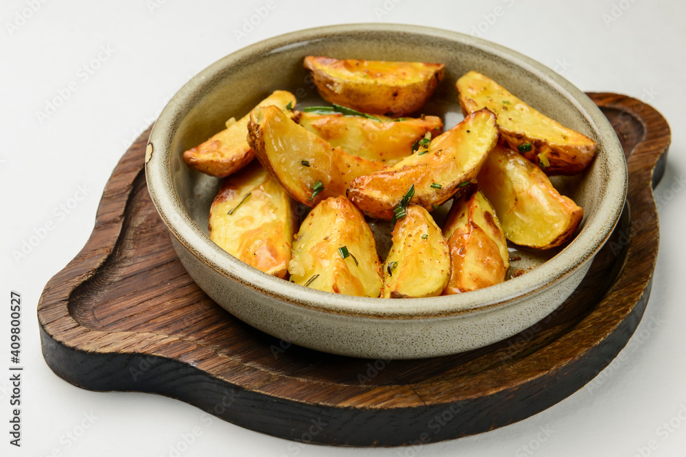 Baked potato with rosemary served in a ceramic bowl over white background. Delicious idea for dinner. Baked potato with rosemary served in a ceramic bowl over white background. Delicious idea for dinner.