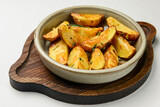 Baked potato with rosemary served in a ceramic bowl over white background. Delicious idea for dinner.