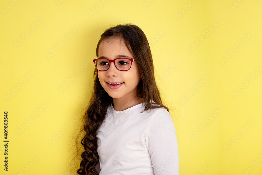 Obraz premium Funny child girl in glasses on colored background