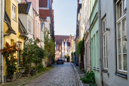 Fototapeta Naklejka Na Ścianę i Meble -  Beautiful cozy courtyard with old houses and flowers in the street of old town Lubeck, Germany