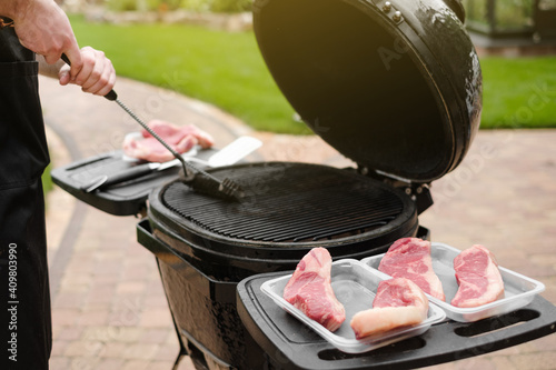 Prepare and clean the grill before starting cooking meat and barbecue. Pieces of meat steaks are placed on pallets before cooking. Cleaning the grill before cooking. Weekend party. Food.
