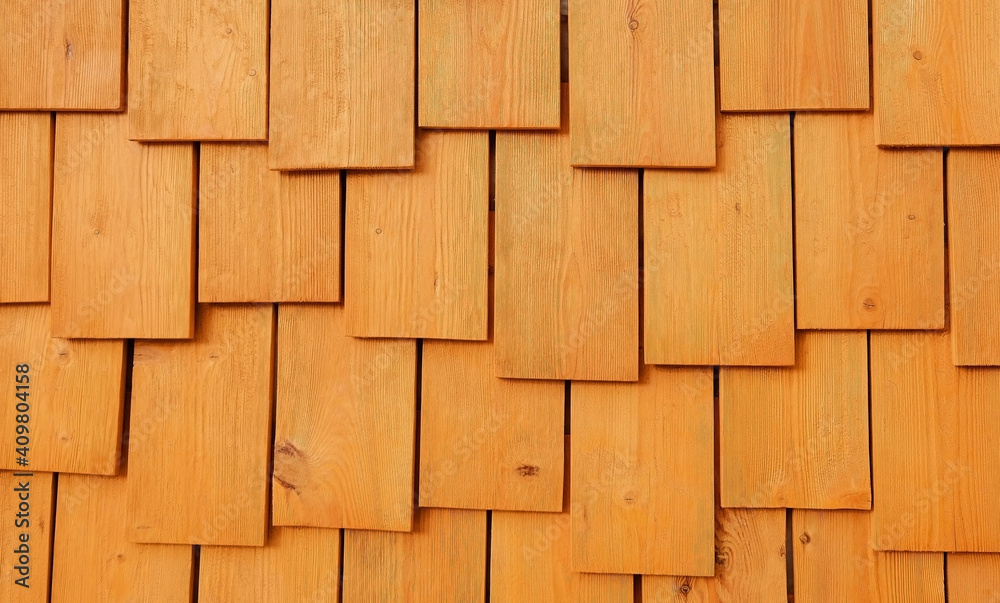 The wall of wooden boards is yellow-orange. The theme of the structure and texture. Layering. Interior design. Eco-friendly materials in construction. Ecology concept. The wall of wooden boards is yellow-orange. The theme of the structure and texture. Layering. Interior design. Eco-friendly materials in construction. Ecology concept.