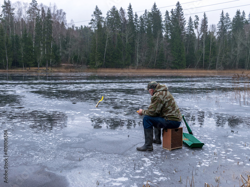 winter angler fishing on ice