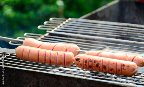 Sausages are cooked on a grill on coals . BBQ, outdoor barbecue . photo