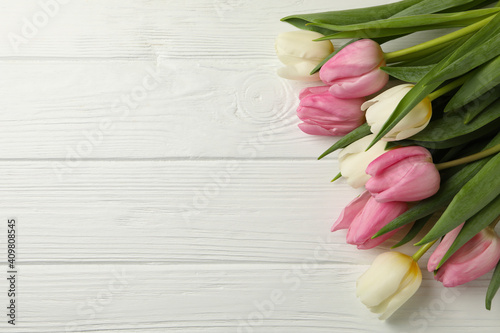 Bouquet of tulips on white wooden background, space for text