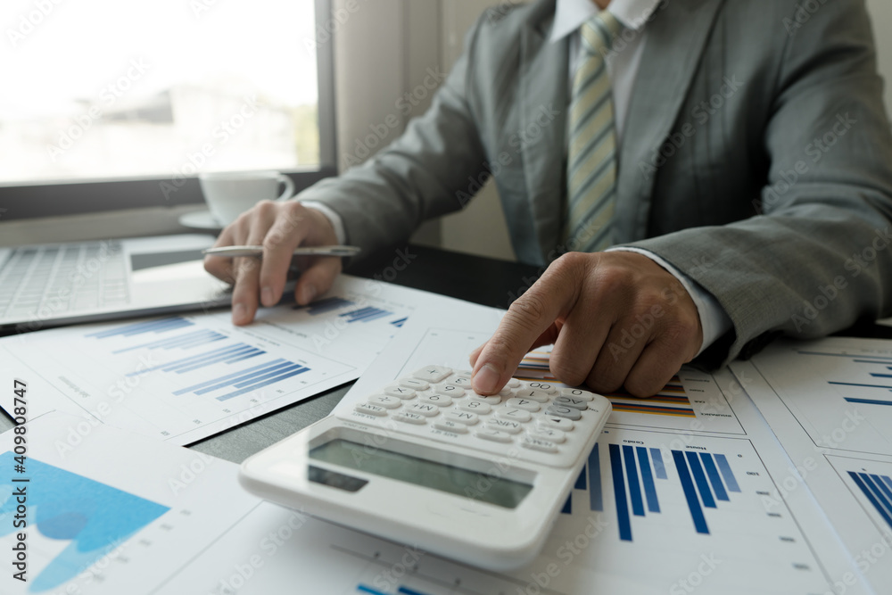 businessman working on desk office with using a calculator to calculate the numbers, finance accounting concept businessman working on desk office with using a calculator to calculate the numbers, finance accounting concept