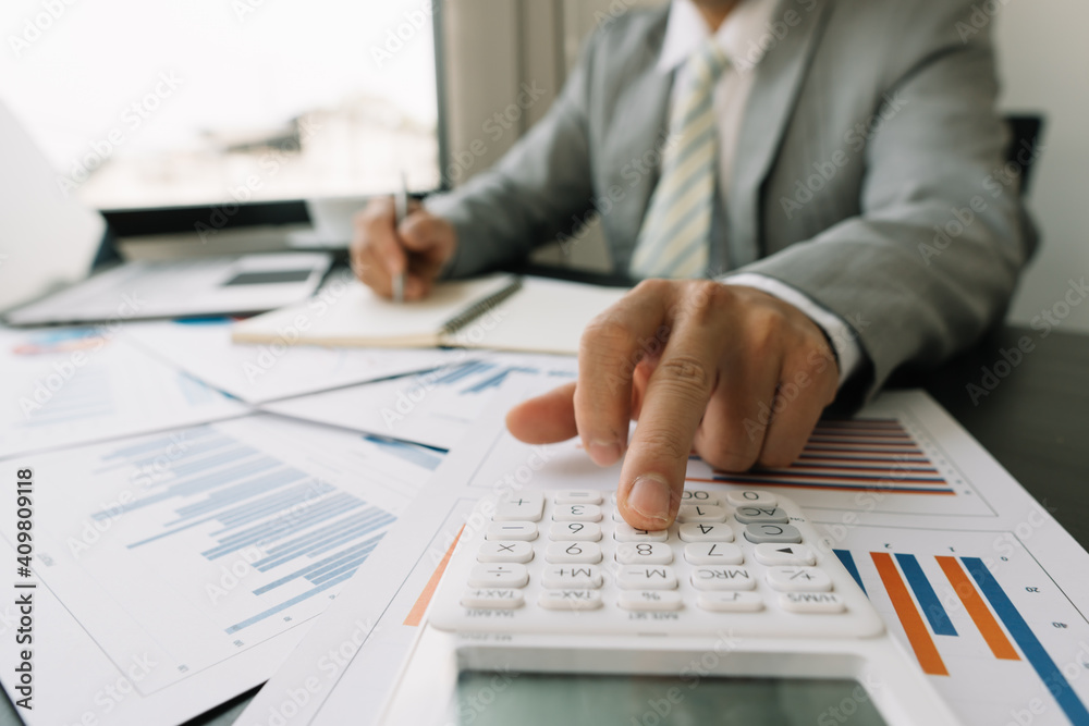 Business people work on the table to analyze financial budgets using a calculator To calculate numbers and liabilities Financial accounting concept Business people work on the table to analyze financial budgets using a calculator To calculate numbers and liabilities Financial accounting concept
