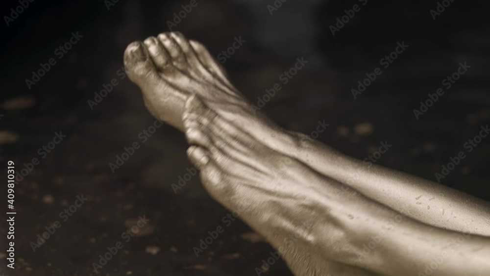 female feet covered golden dye in water, closeup view female feet covered golden dye in water, closeup view