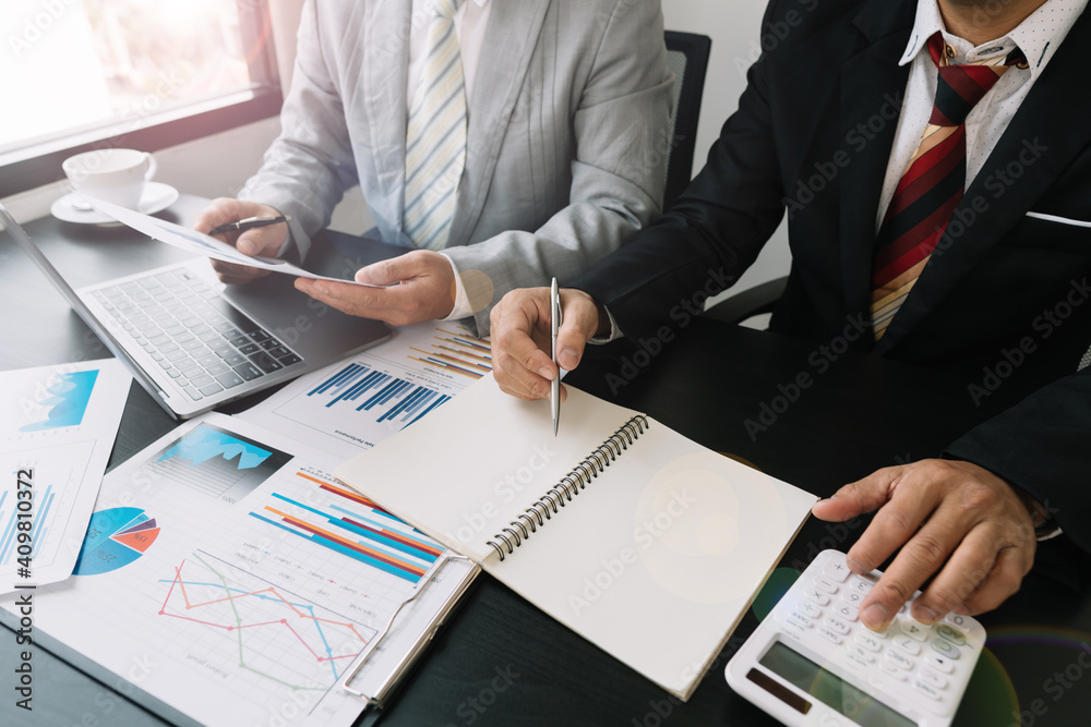 A group of professional business people sit on a meeting table in the