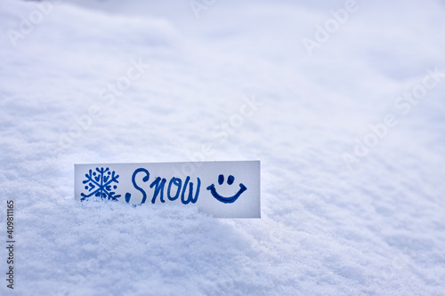 fresh white fluffy snow, snowdrift on the street, inscription snow on a piece of paper, snowflake pattern, snow texture in winter season