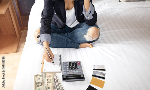 selective focus of woman hand with calculator  and credit cards which she is  unemployment and personal bankruptcy in the bed room