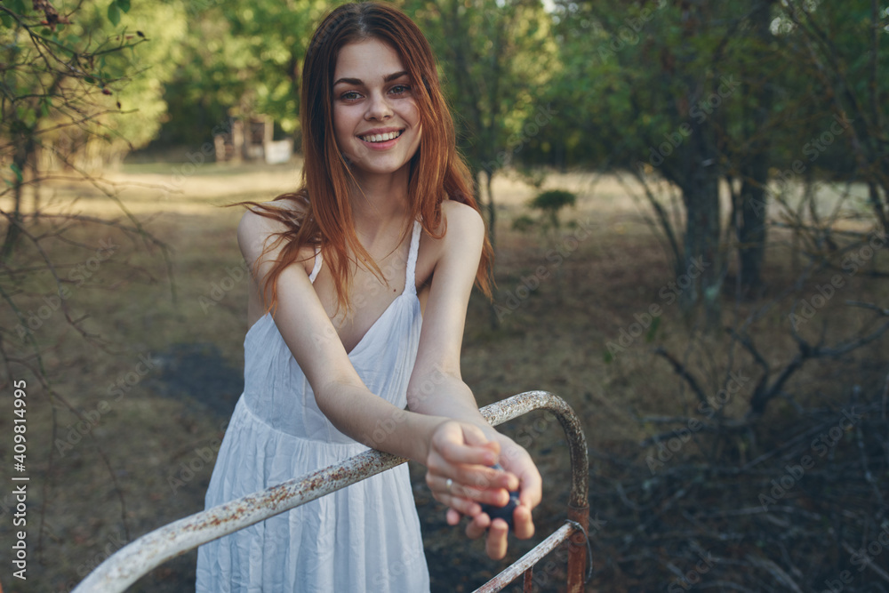 happy woman with a bunch of grapes leaned on an iron bed outdoors in the garden happy woman with a bunch of grapes leaned on an iron bed outdoors in the garden