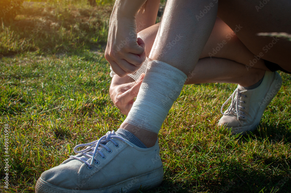 The girl injured the tendons on her leg during an outdoor jogging. Self-bandaging.