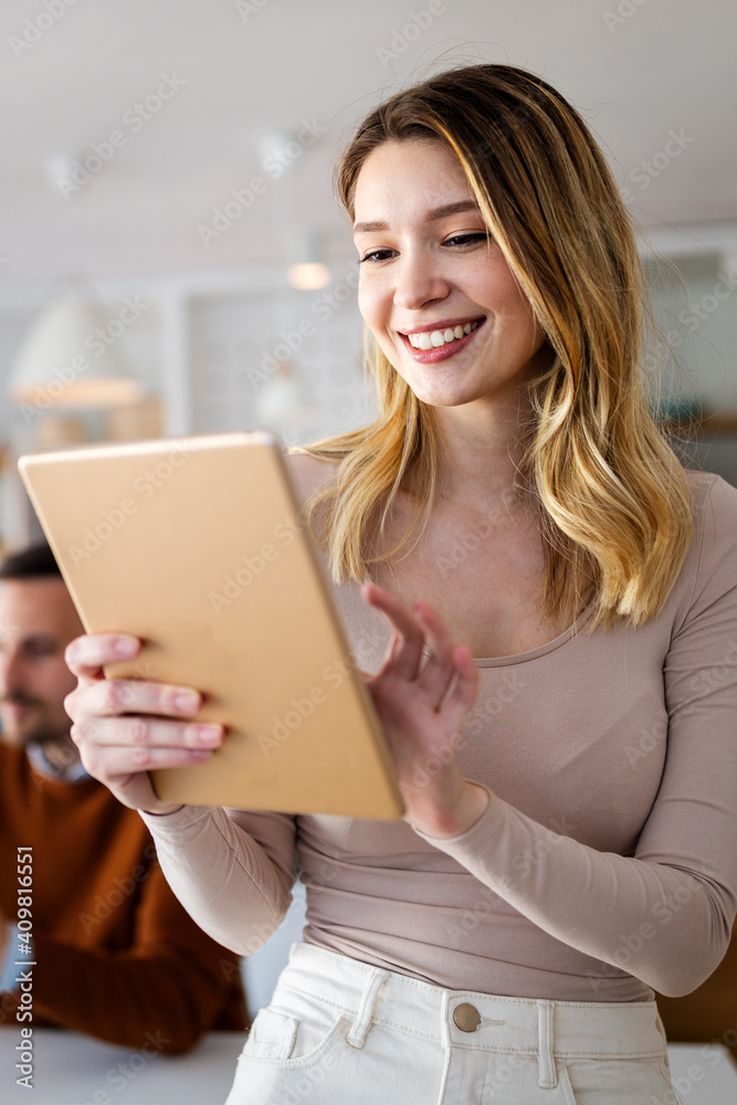 Beautiful young designer woman working on tablet in office. Beautiful young designer woman working on tablet in office.