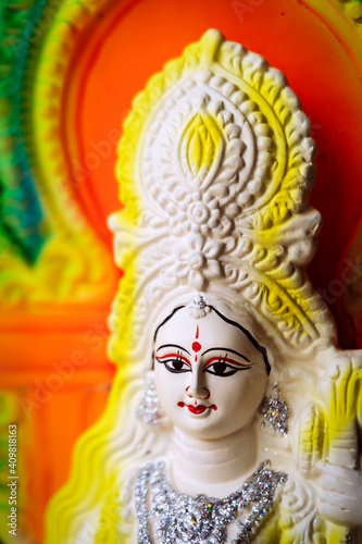 Closeup Of Saraswati. Idol of Goddess Saraswati painted in white and yellow colour on Basant panchami utsav. Swaraswati is a God of knowledge, music, art, wisdom and learning. Hindu Puja Background.