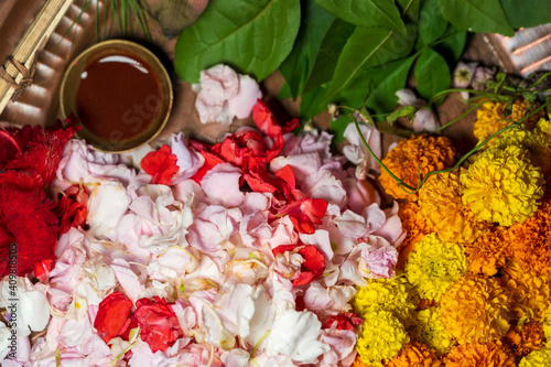 Hindu Puja Thali Of Flowers. Pooja thali full of marigold flowers, petals, leaves and chandan for pushpanjali on Vasant Panchami or saraswati, Lakshmi, Durga puja. Hindu worship ritual background. photo