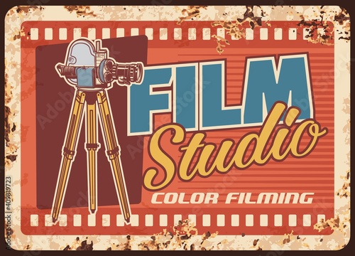 Film studio rusty metal plate, cinema or movie entertainment vector rust tin sign. Vintage video camera with film reels retro poster. Color filming, cinematography industry card with old camcorder