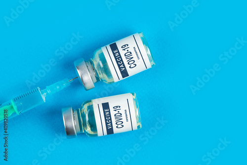 Vaccination. Syringe and vaccine COVID-19. Coronavirus on blue background
