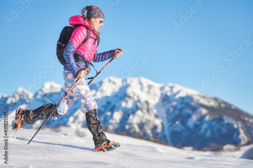Young sporty woman in the snow with crampons and gaiters