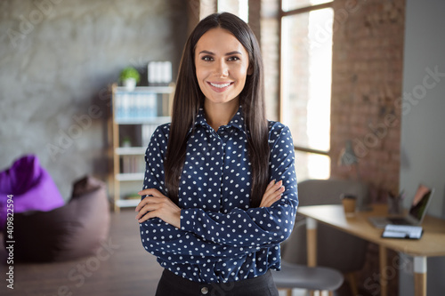Photo of young beautiful attractive cheerful smiling happy confident businesswoman with crossed hands at office workshop