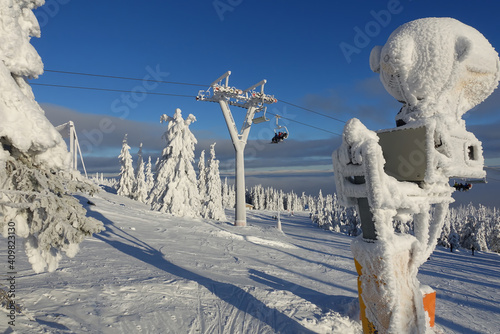 Snow machine in a frozen arctic landscape in norway near Trysil on a ski piste with ski lift photo