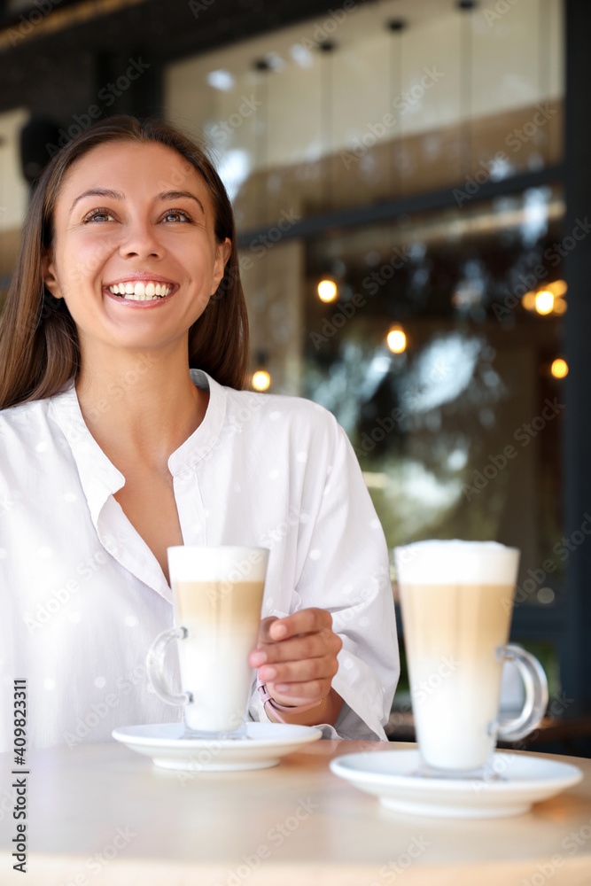 Beautiful young woman with coffee at table in cafe Beautiful young woman with coffee at table in cafe