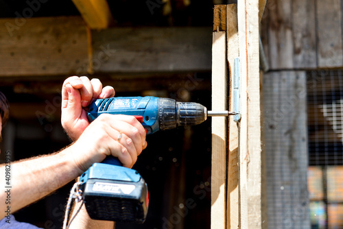 Master's hands with a screwdriver, drill. Repair, do it yourself, building a house, a barn, a summer residence, working with wood. manual labor.