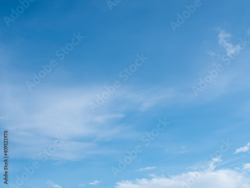 Blue sky background with white clouds on bright summer day.