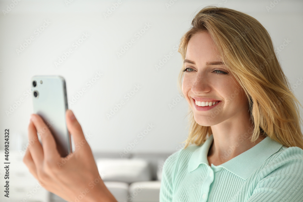 Young woman unlocking smartphone with facial scanner indoors. Biometric verification Young woman unlocking smartphone with facial scanner indoors. Biometric verification