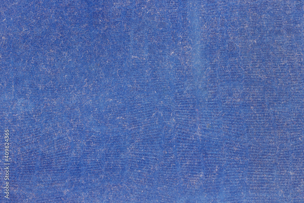 The surface is old blue velvet, covered with dust and fibers. The texture of a dirty, worn cover of an old book. The surface is old blue velvet, covered with dust and fibers. The texture of a dirty, worn cover of an old book.
