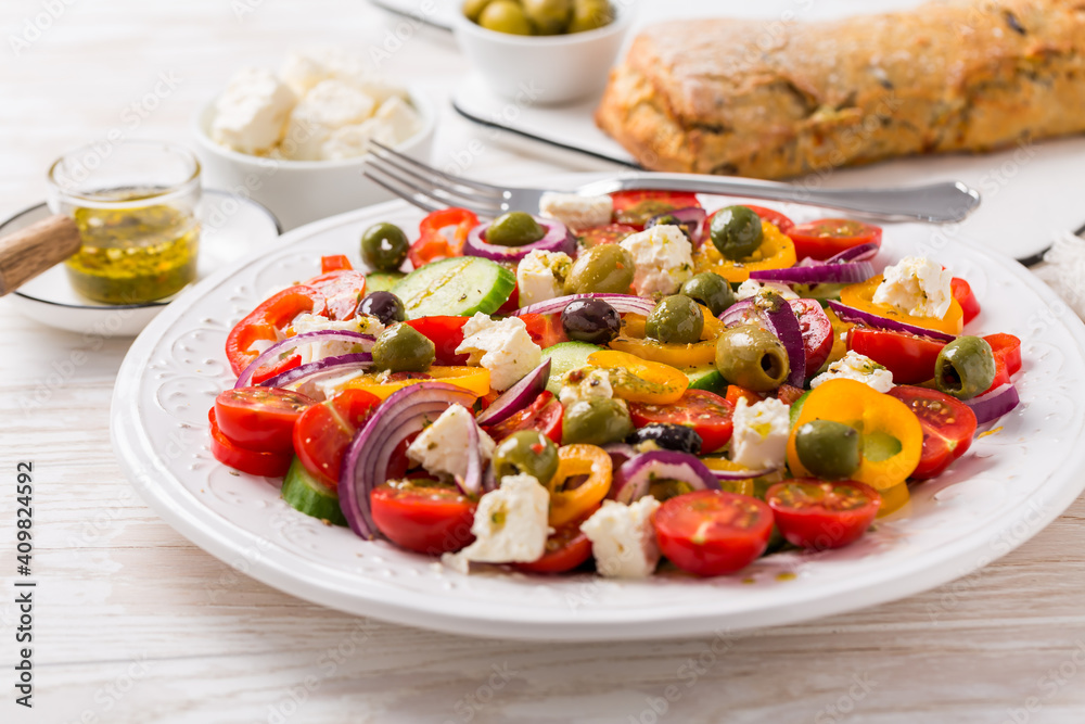 Greek salad of fresh cucumber, tomato, sweet pepper, red onion, feta cheese and olives with olive oil dressing