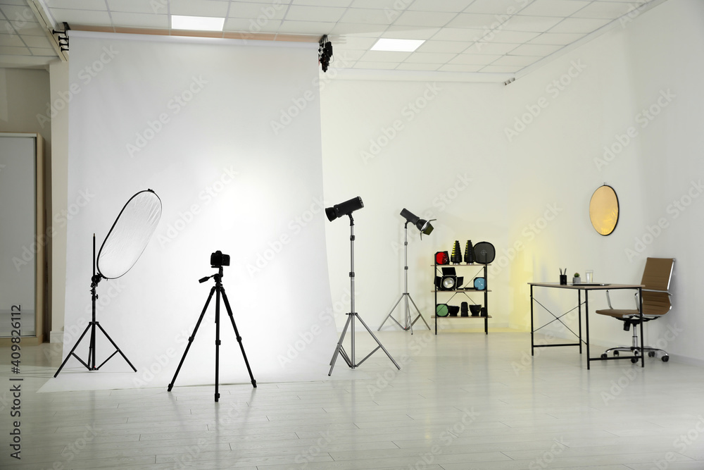 Photo studio interior with set of professional equipment and workplace