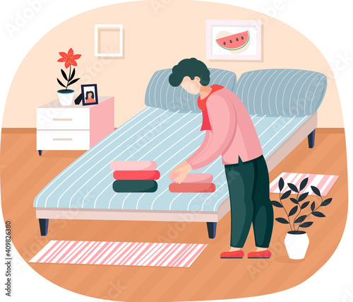 Young man householder puts bedclothes in order at home standing near bed in bedroom neatly stacks laundry. Household affairs tidy home. Family members activity for order things in their places