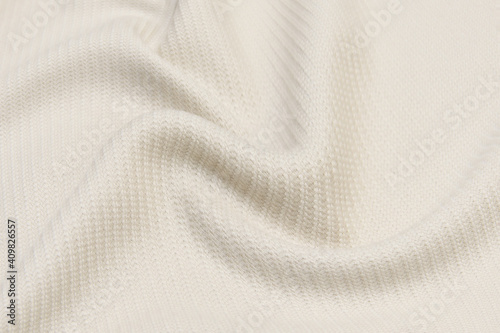 Fotografía Beige knitted woolen background. Knitwear fabric texture.