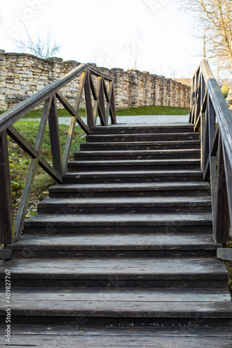 Old wooden staircase leading upwards  vertical photo  rural staircase with railings