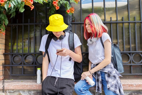 Teenagers students guy and girl look in smartphone screen