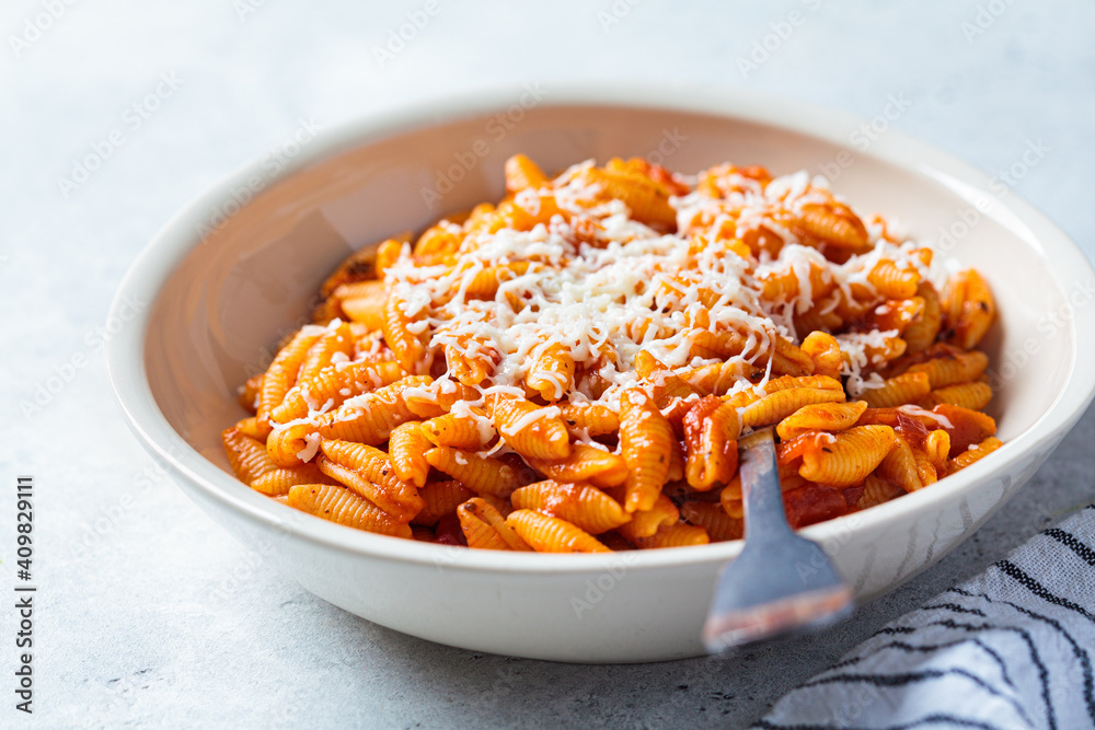 Gnocchetti sardi pasta in tomato sauce with cheese, gray background. Italian pasta concept Gnocchetti sardi pasta in tomato sauce with cheese, gray background. Italian pasta concept