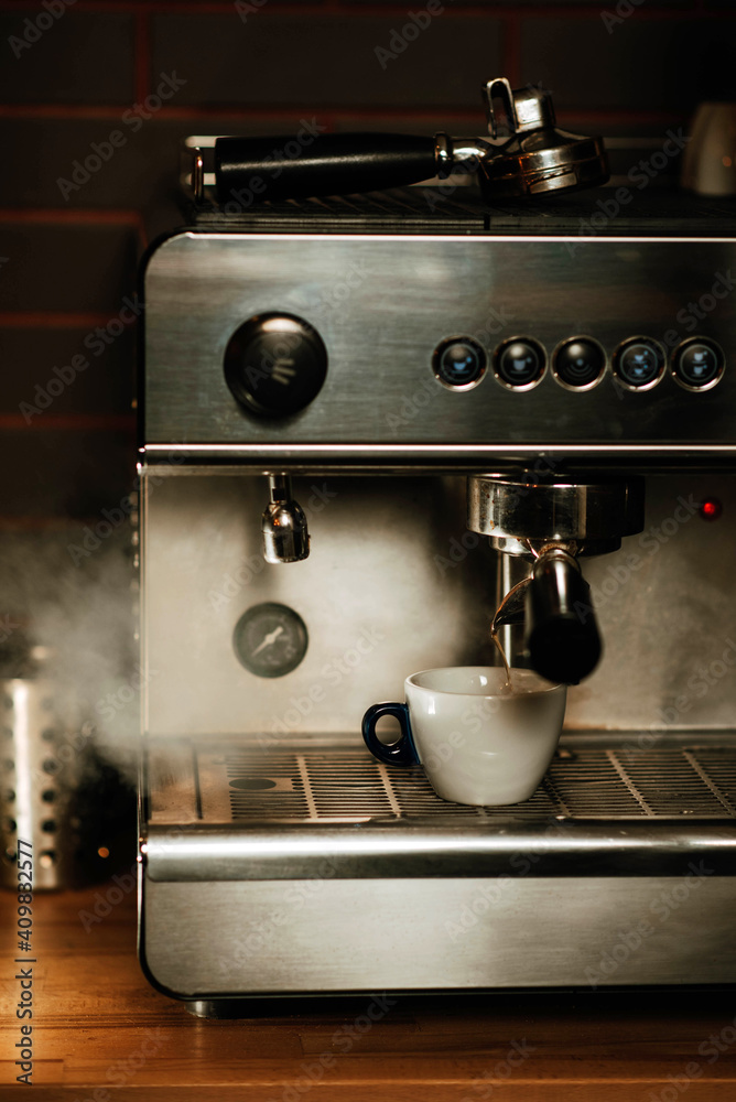 The retro coffee machine is dispensing steam