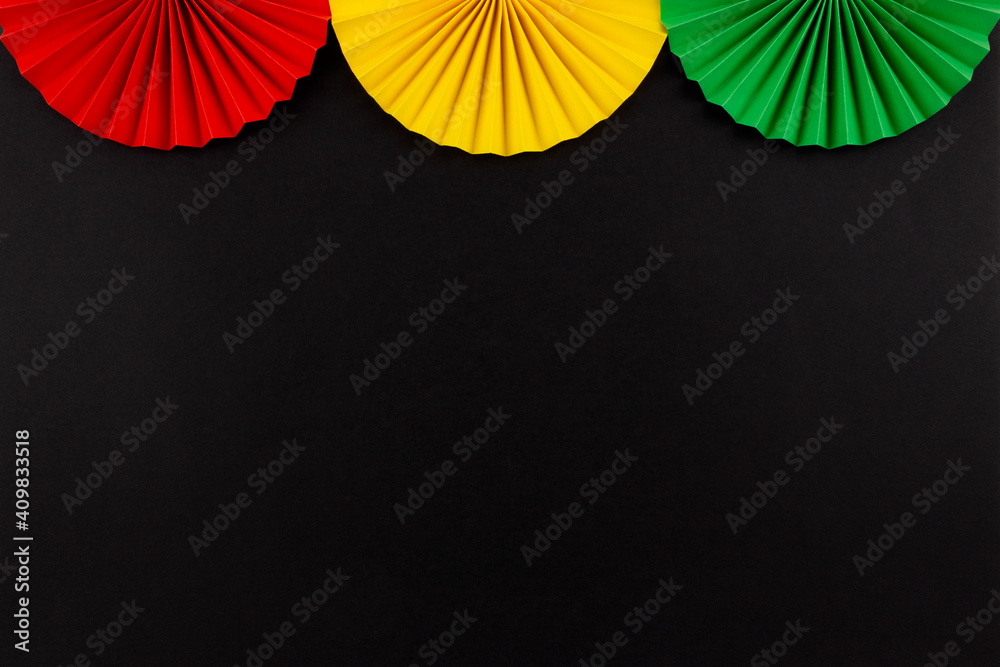 Red, yellow and green color origami flowers on the black background. - obrazy, fototapety, plakaty 