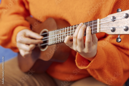 Girl learns to play the ukulele at home