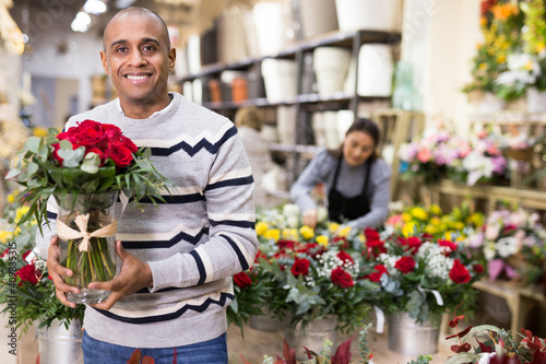 Male customer chooses flowers in flower shop