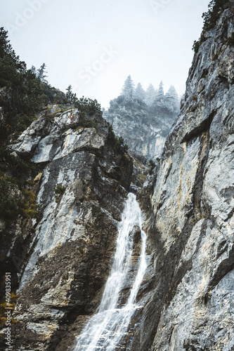 waterfall at lake Oeschinensee on a cloudy autumn day
