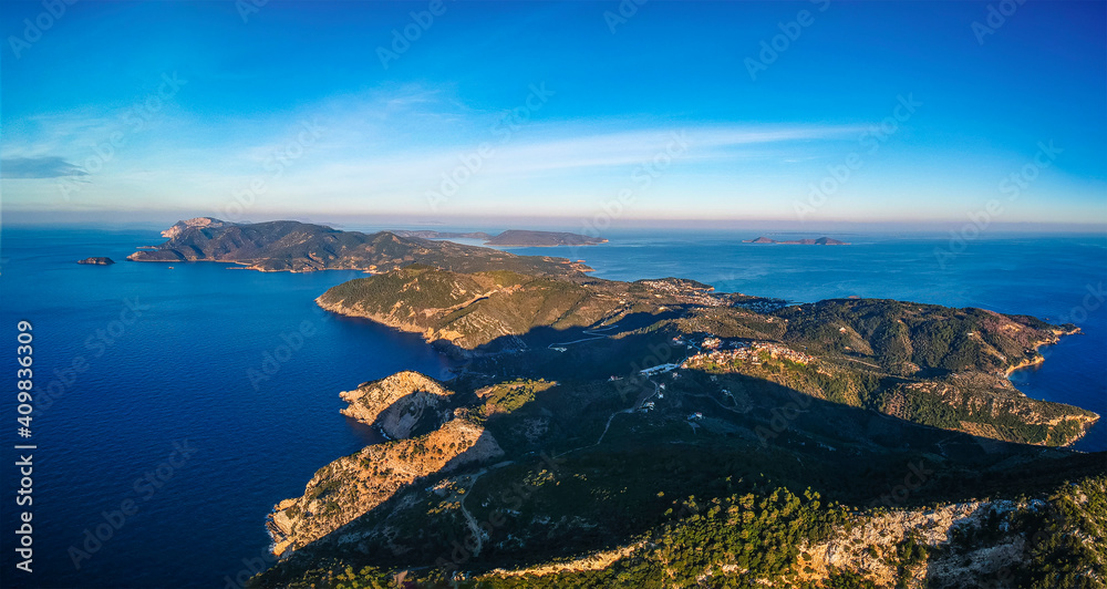 Aerial drone view over western Alonnisos towards Skopelos island at sunset. Natural landscape, beautiful rocky scenery, spectacular view in Sporades, Aegean sea, Greece