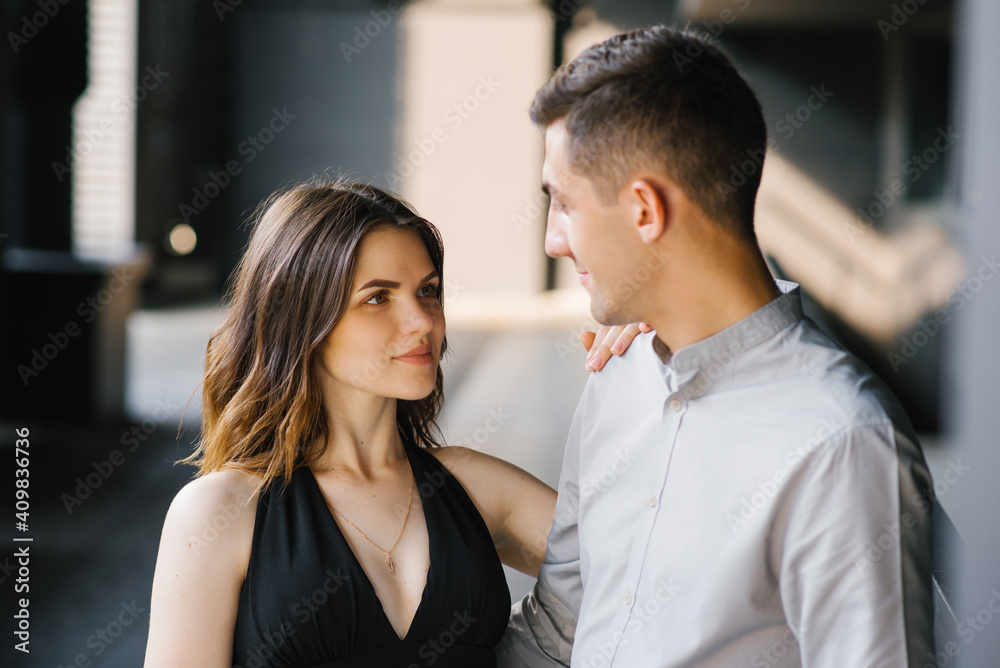 Portrait of a young beautiful couple. The girl looks into the eyes of her loved one and smiles. First date and the concept of tenderness Portrait of a young beautiful couple. The girl looks into the eyes of her loved one and smiles. First date and the concept of tenderness