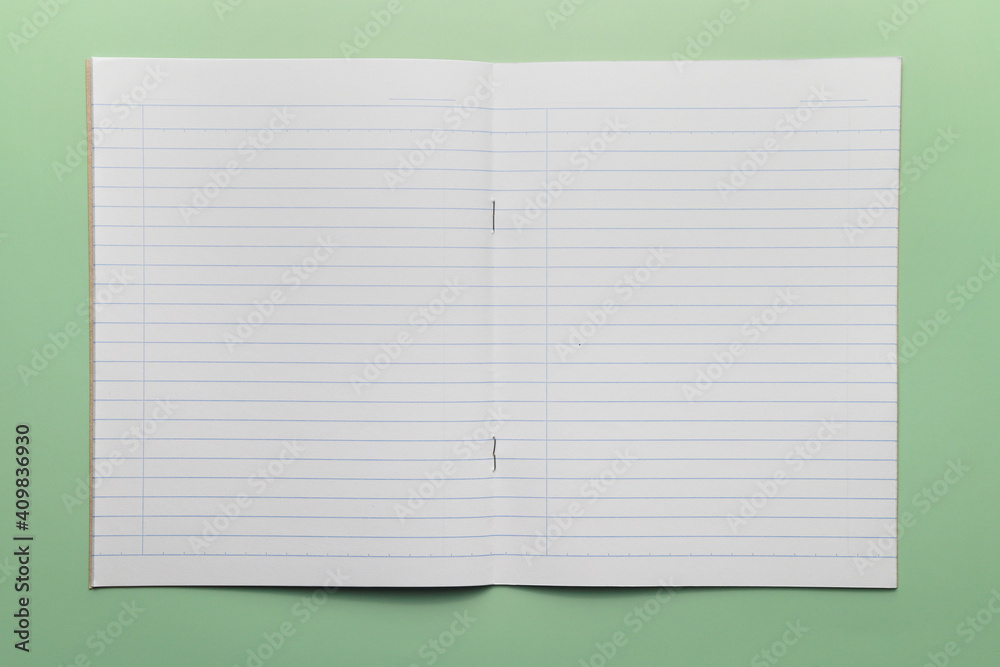 Top view notepad or notebook paper isolated on a green background. Top view notepad or notebook paper isolated on a green background.