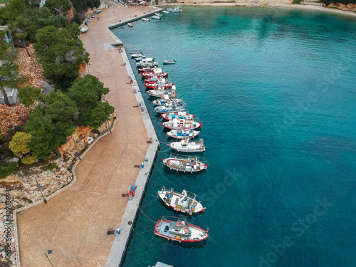 Aerial view over Votsi beach (Paralia Votsi) and the picturesque port with traditional wooden fishing boats in Alonnisos island during Winter period in Sporades, Greece photo