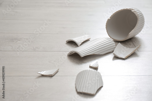 Photography Broken white ceramic vase on wooden floor