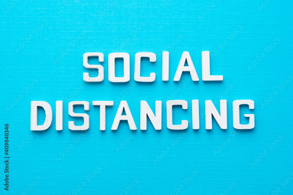 Social distancing word wooden letters blue background. Social distancing word wooden letters blue background.